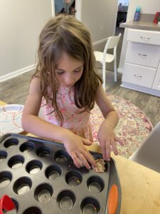 Child working with a baking tray during sensory play